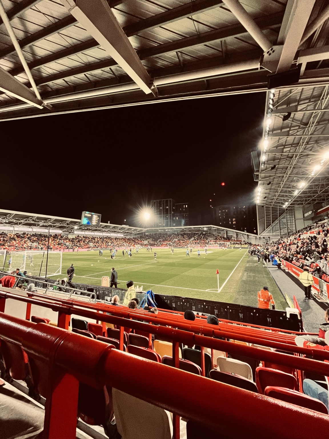 Het Gtech Community Stadium tijdens een avondwedstrijd